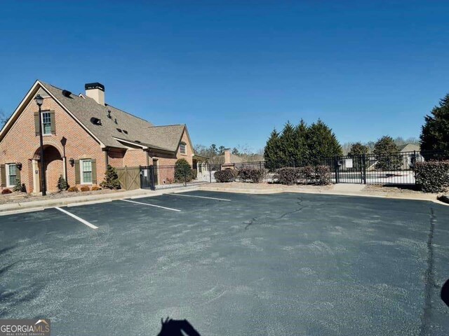 4140 Lanier Ridge Walk Unit 104, Cumming, GA 30041 - uncovered parking lot featuring a gate