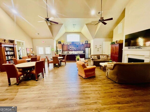 4140 Lanier Ridge Walk Unit 104, Cumming, GA 30041 - living room with wood finished floors, ceiling fan, a fireplace, and high vaulted ceiling