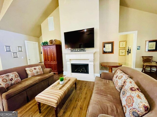 4140 Lanier Ridge Walk Unit 104, Cumming, GA 30041 - living room featuring high vaulted ceiling, wood finished floors, and a fireplace
