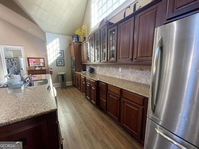 4140 Lanier Ridge Walk Unit 104, Cumming, GA 30041 - kitchen featuring freestanding refrigerator, glass insert cabinets, dark wood-type flooring, decorative backsplash, and high vaulted ceiling