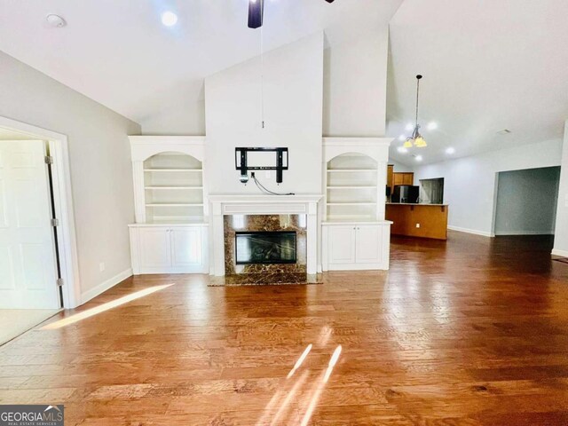 4140 Lanier Ridge Walk Unit 104, Cumming, GA 30041 - unfurnished living room with high vaulted ceiling, wood finished floors, a ceiling fan, a premium fireplace, and built in features