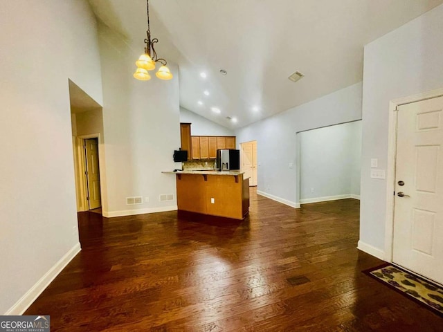 kitchen with high vaulted ceiling, decorative light fixtures, a kitchen bar, stainless steel fridge with ice dispenser, and dark wood-type flooring