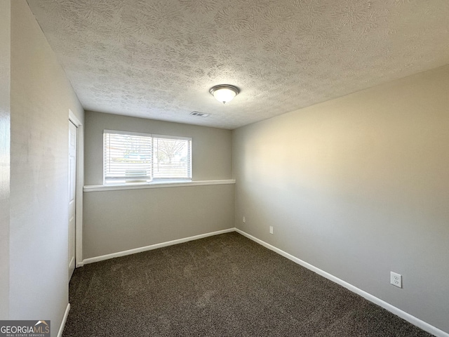 carpeted empty room with a textured ceiling