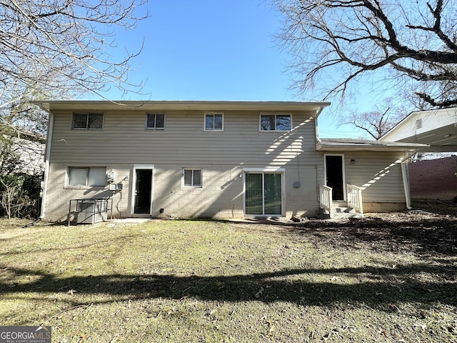 rear view of house featuring a lawn