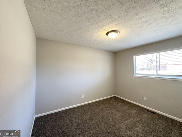 spare room with carpet flooring and a textured ceiling