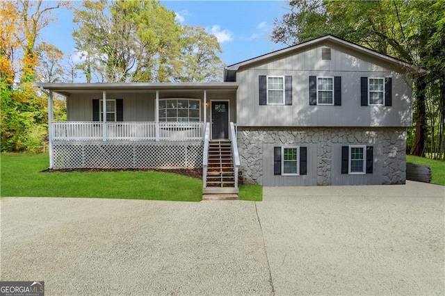 tri-level home with covered porch and a front yard