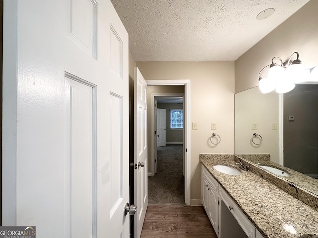 bathroom featuring hardwood / wood-style floors, vanity, and a textured ceiling