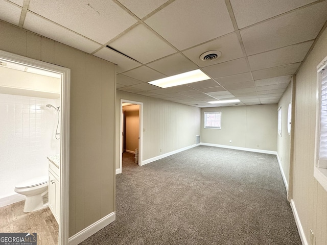 basement featuring a paneled ceiling and carpet floors