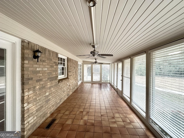 unfurnished sunroom featuring ceiling fan