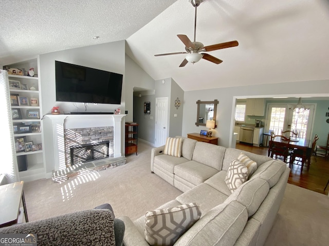 living room featuring a textured ceiling, lofted ceiling, a stone fireplace, built in features, and ceiling fan