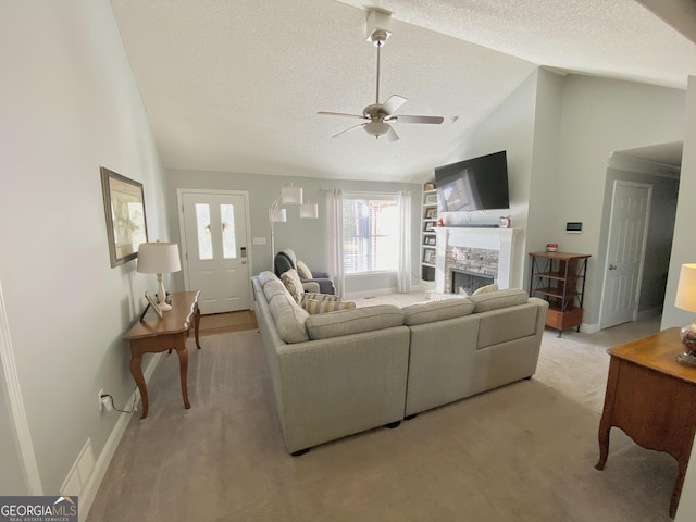 living room featuring ceiling fan, a textured ceiling, lofted ceiling, and a fireplace