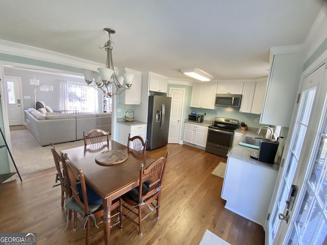 dining area featuring dark hardwood / wood-style flooring, crown molding, and a chandelier