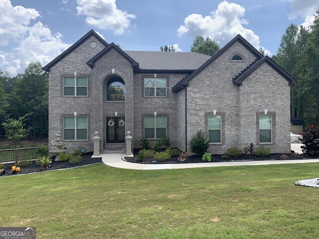 french provincial home featuring french doors and a front yard