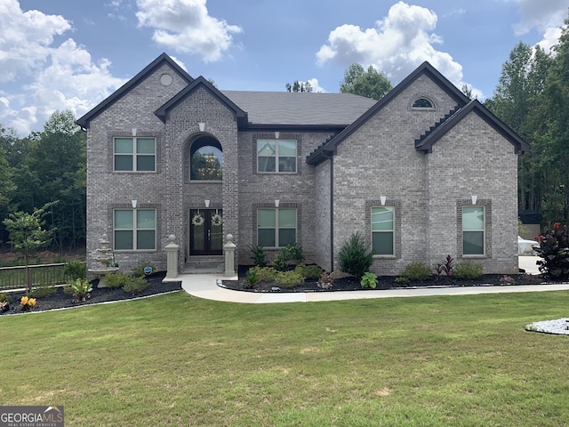 french country style house with a front lawn