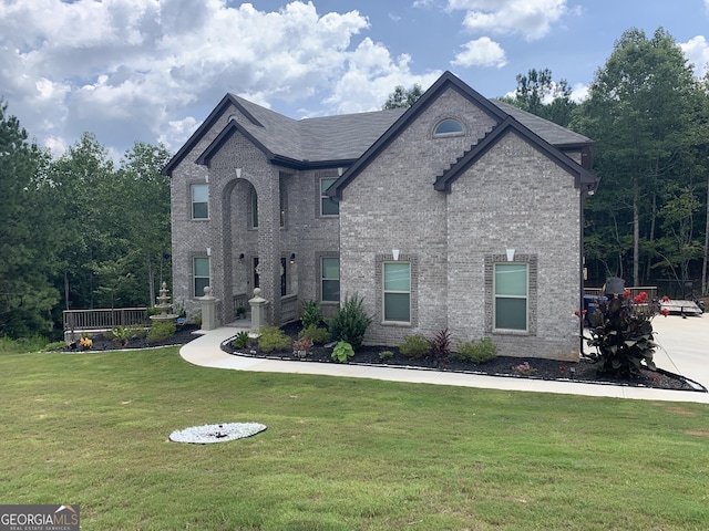 french country inspired facade featuring a front yard