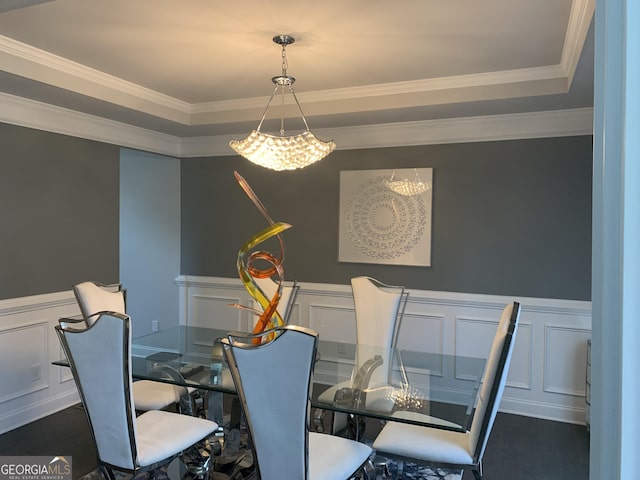 dining room with dark hardwood / wood-style flooring, a tray ceiling, and ornamental molding