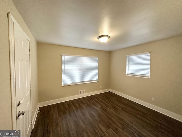 unfurnished room with dark hardwood / wood-style floors