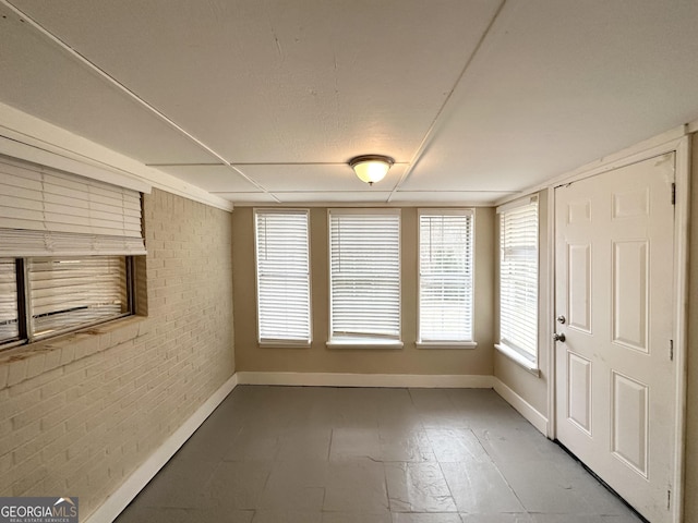 empty room featuring brick wall