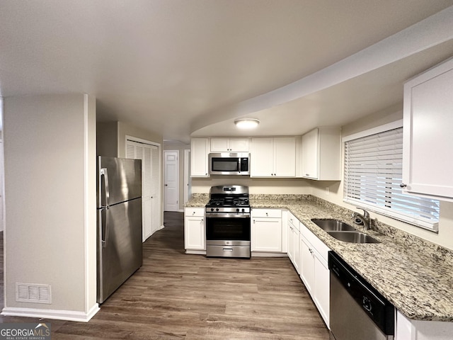 kitchen with white cabinets, wood-type flooring, sink, and appliances with stainless steel finishes