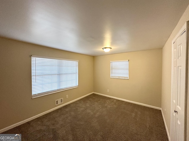 empty room with dark colored carpet