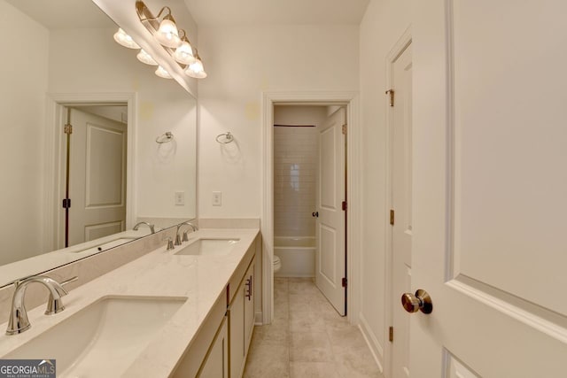 full bathroom with tiled shower / bath, vanity, and toilet