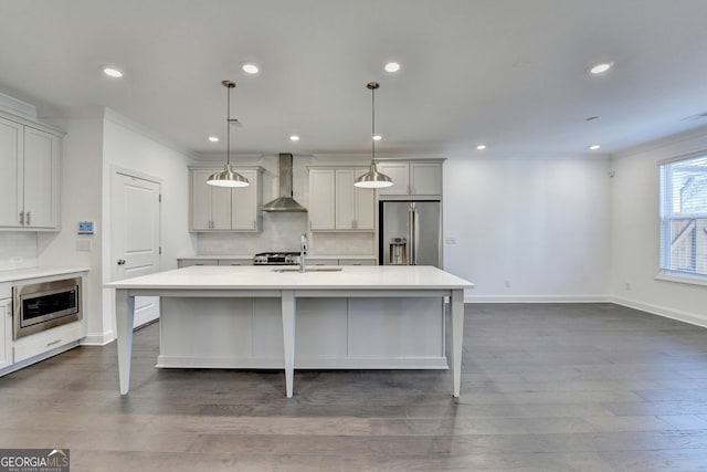 kitchen featuring an island with sink, wall chimney exhaust hood, and stainless steel appliances