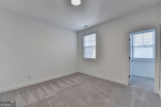 spare room with plenty of natural light and light carpet