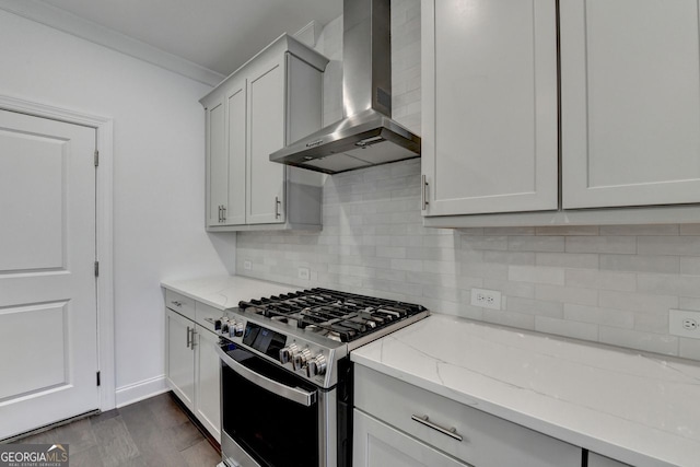 kitchen featuring wall chimney exhaust hood, tasteful backsplash, stainless steel range with gas cooktop, light stone counters, and crown molding