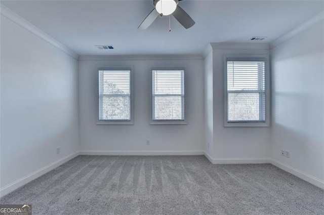 carpeted empty room with ceiling fan, crown molding, and a healthy amount of sunlight