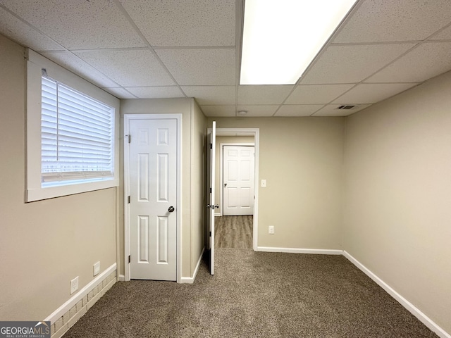 interior space with a drop ceiling and carpet