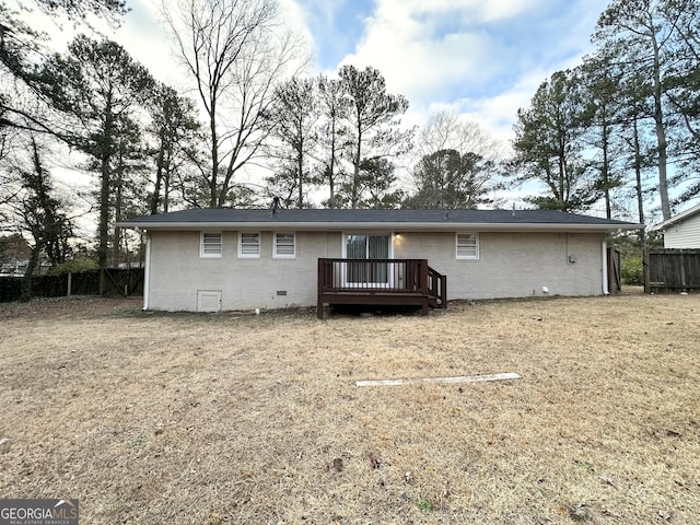 back of house featuring a wooden deck and a lawn