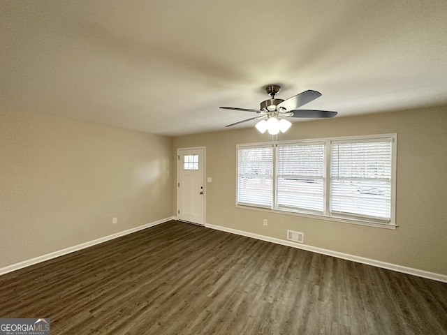 empty room featuring ceiling fan and dark wood-type flooring