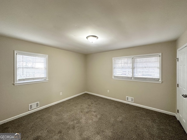 carpeted spare room featuring plenty of natural light