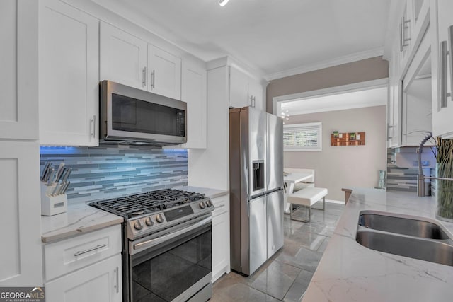 kitchen with white cabinetry, appliances with stainless steel finishes, and light stone countertops