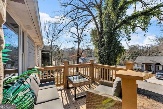 wooden terrace with an outdoor living space