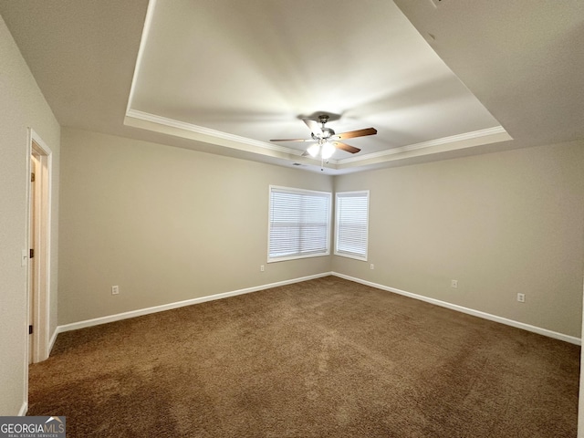 spare room featuring a raised ceiling, ceiling fan, and carpet floors