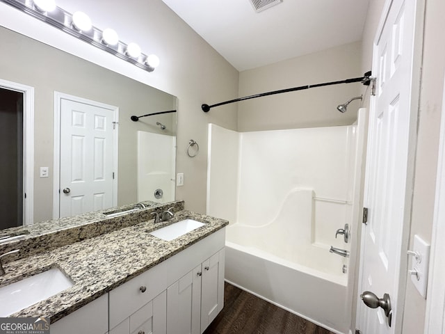 bathroom with shower / bathing tub combination, wood-type flooring, and vanity