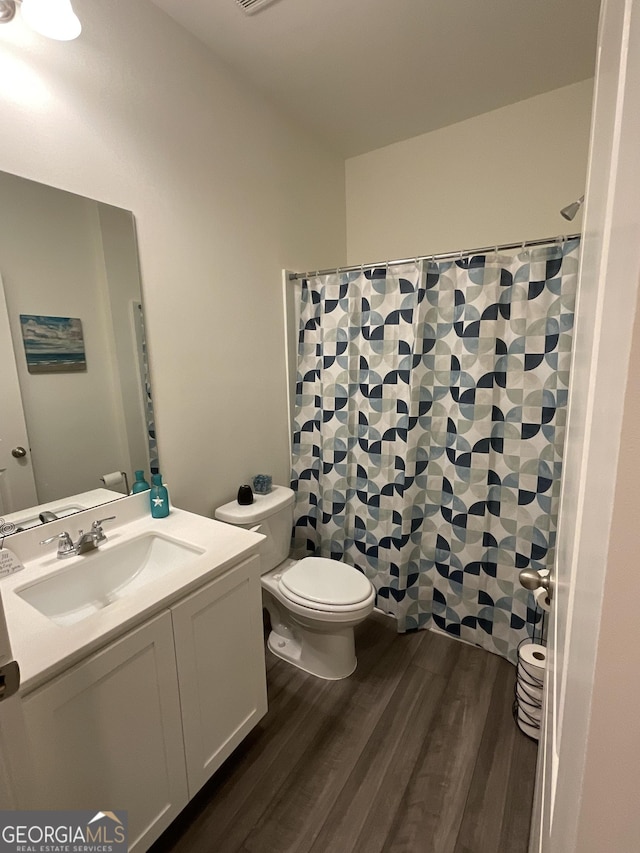 bathroom with a shower with shower curtain, vanity, wood-type flooring, and toilet