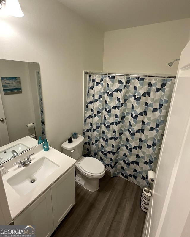 bathroom featuring toilet, vanity, and hardwood / wood-style flooring