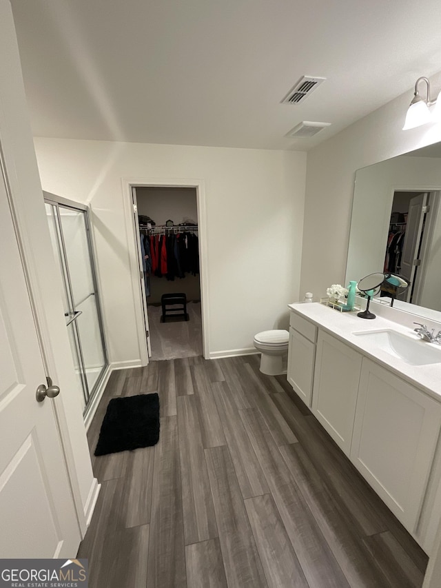 bathroom featuring vanity, wood-type flooring, and a shower with shower door