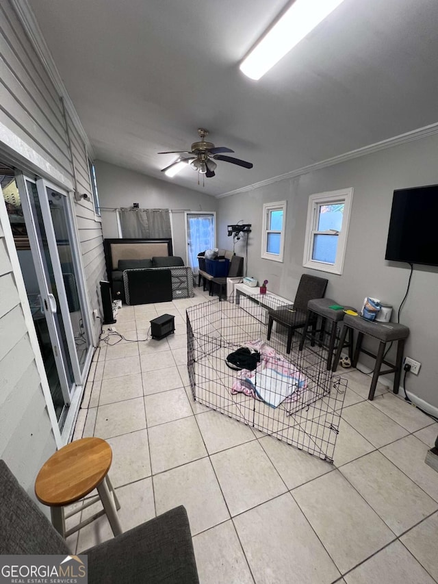 living room with tile patterned flooring, ceiling fan, lofted ceiling, and crown molding