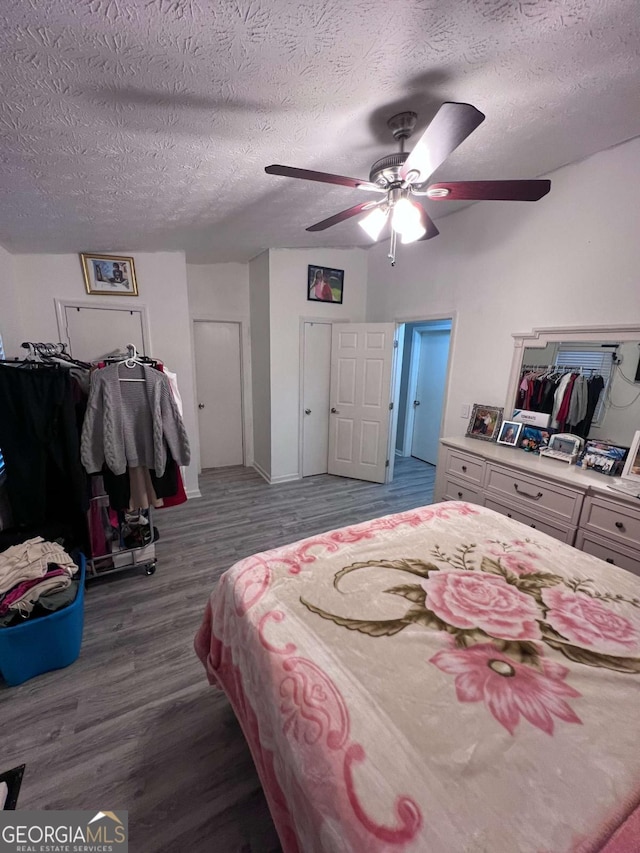 bedroom featuring ceiling fan, hardwood / wood-style floors, and a textured ceiling