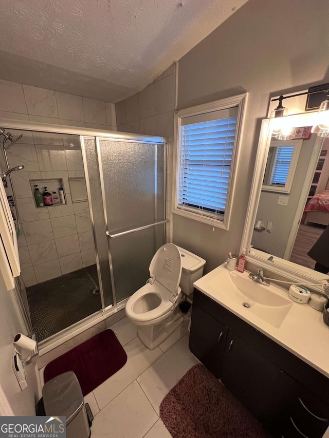 bathroom with tile patterned floors, a textured ceiling, vanity, toilet, and a shower with shower door