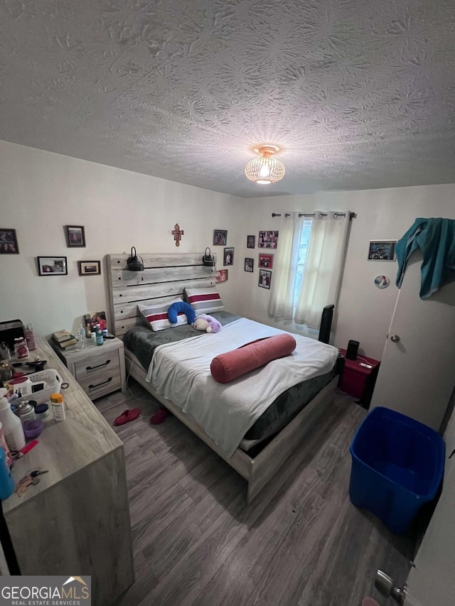 bedroom featuring hardwood / wood-style flooring and a textured ceiling