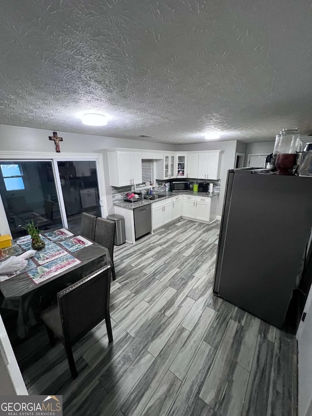 kitchen with sink, light hardwood / wood-style flooring, a textured ceiling, appliances with stainless steel finishes, and white cabinetry