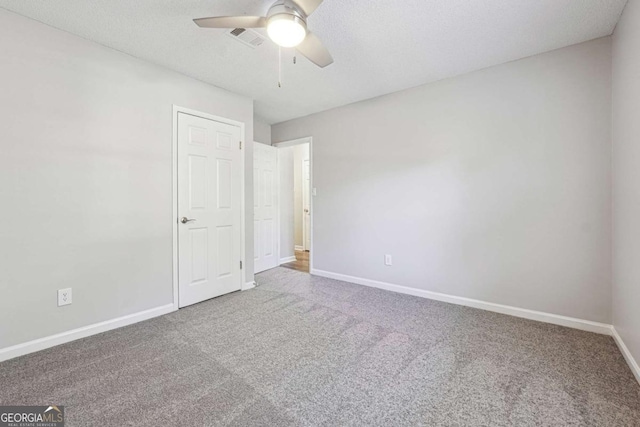 carpeted empty room featuring ceiling fan