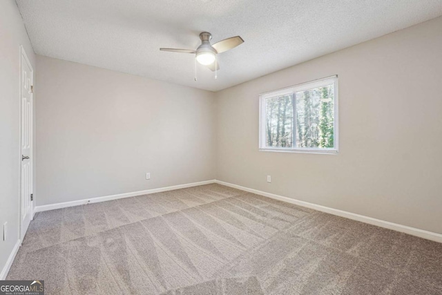 carpeted spare room with a textured ceiling and ceiling fan