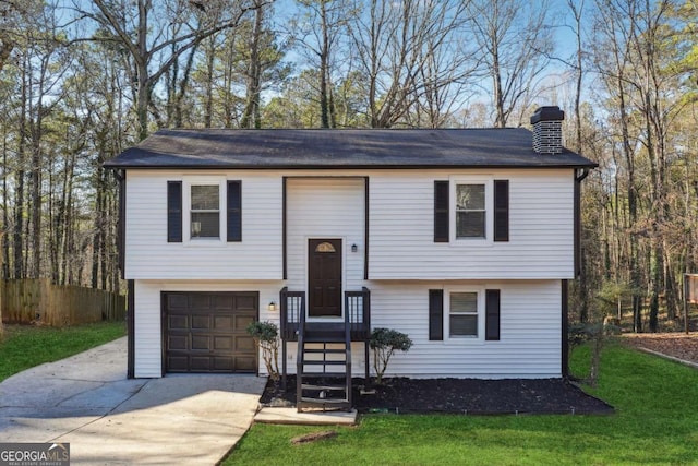 split foyer home featuring a garage and a front lawn