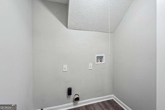 clothes washing area with electric dryer hookup, hookup for a washing machine, hardwood / wood-style floors, and a textured ceiling