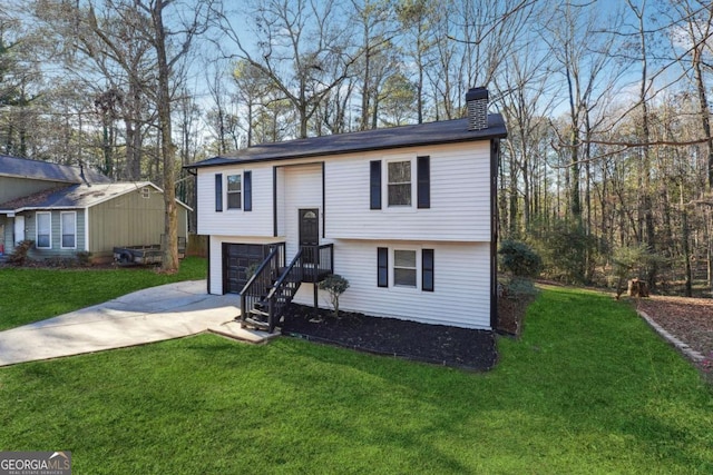 raised ranch featuring a front yard and a garage